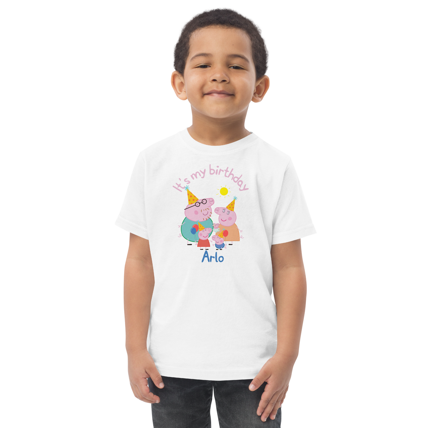 Little boy celebrating his birthday in a Peppa Pig themed shirt featuring cartoon-style characters, colourful bunting, and the phrase 'It's My Birthday' in bright letters