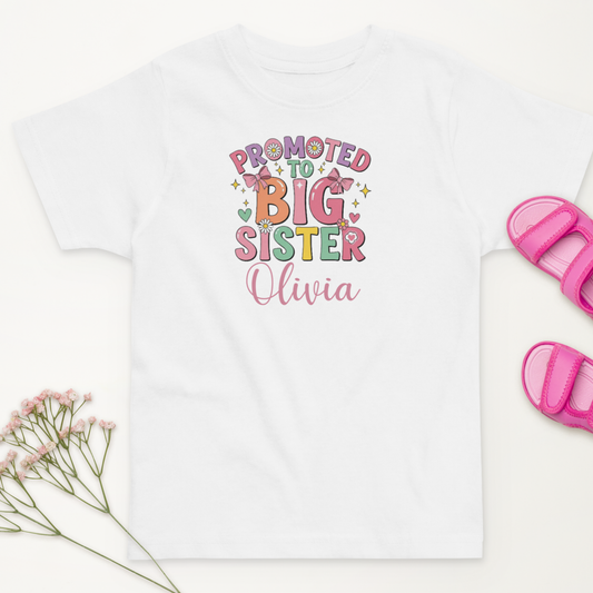 Celebrate your little one’s new role with this personalised “Promoted to Big Sister” t-shirt. Customise it with her name for the perfect sibling announcement or gift!