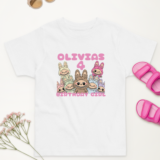 “Pink and pastel kids shirt for birthday with bows and cartoon art”